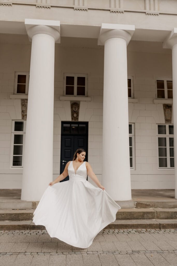 Elegantes Brautkleid vor klassischer weißer Säulenfassade in Bremen.
