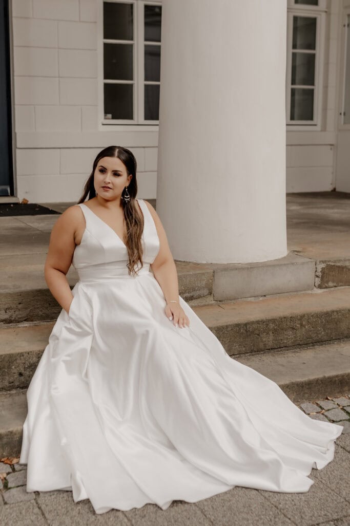 Braut in weißem Hochzeitskleid vor weißen Säulen in Bremen.
