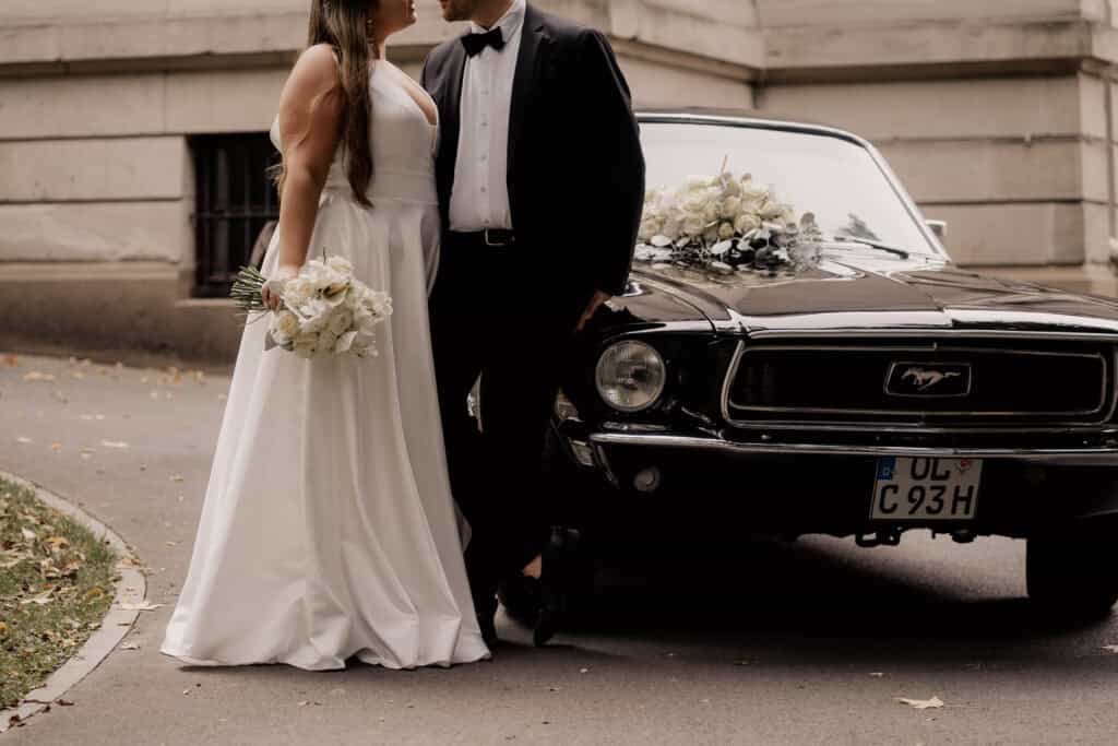 Brautpaar vor einem schwarzen Oldtimer bei einer Hochzeit in Bremen.
