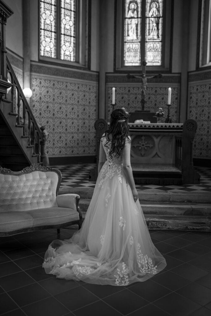 Braut in Hochzeitskleid in Kirche, Innenaufnahme, schwarz-weiß.