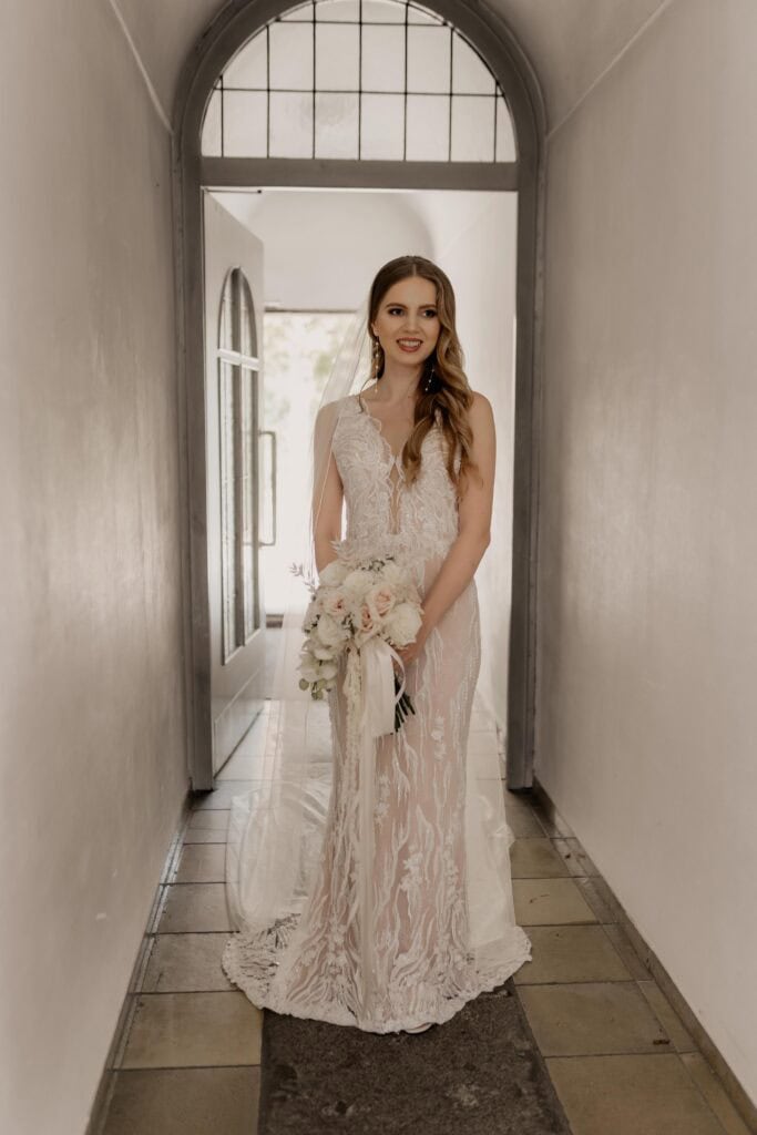 Miriam Weimer im eleganten Hochzeitskleid mit Blumenstrauß.