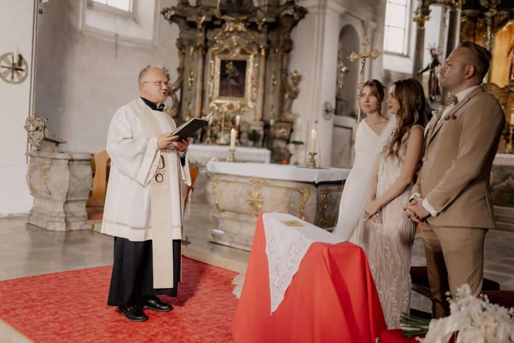 Trauung in der Kirche mit Priester, Brautpaar und Gästen.