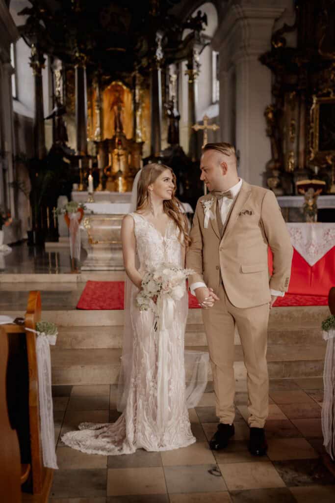 Braut und Bräutigam bei ihrer Hochzeit in der Kirche, liebevoller Moment.