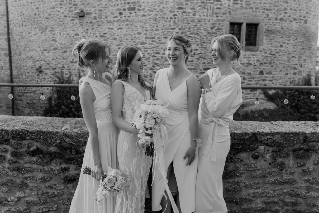 Braut mit Freundinnen bei Hochzeit, lachend und glücklich.