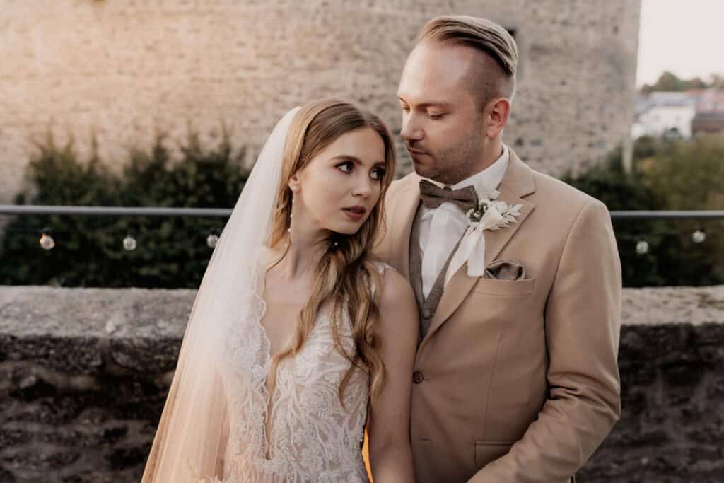 Braut und Bräutigam bei einer Hochzeitsaufnahme im Freien.