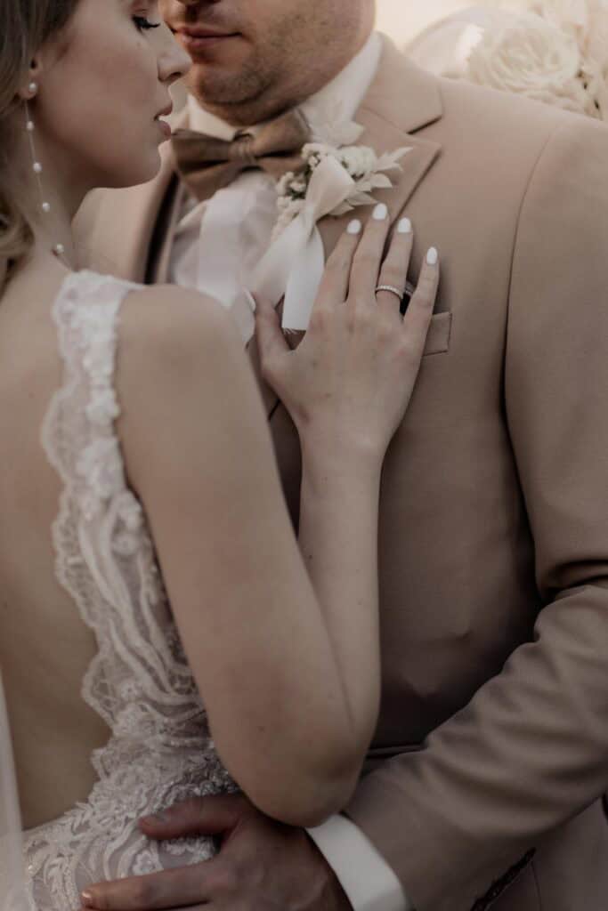 Braut und Bräutigam in inniger Umarmung bei Hochzeit.