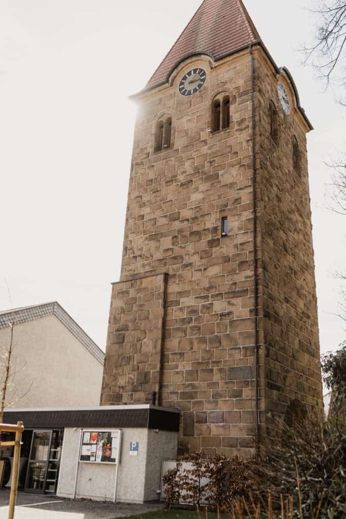 Historischer Uhrturm in einer Stadt, fotografiert bei Tageslicht.