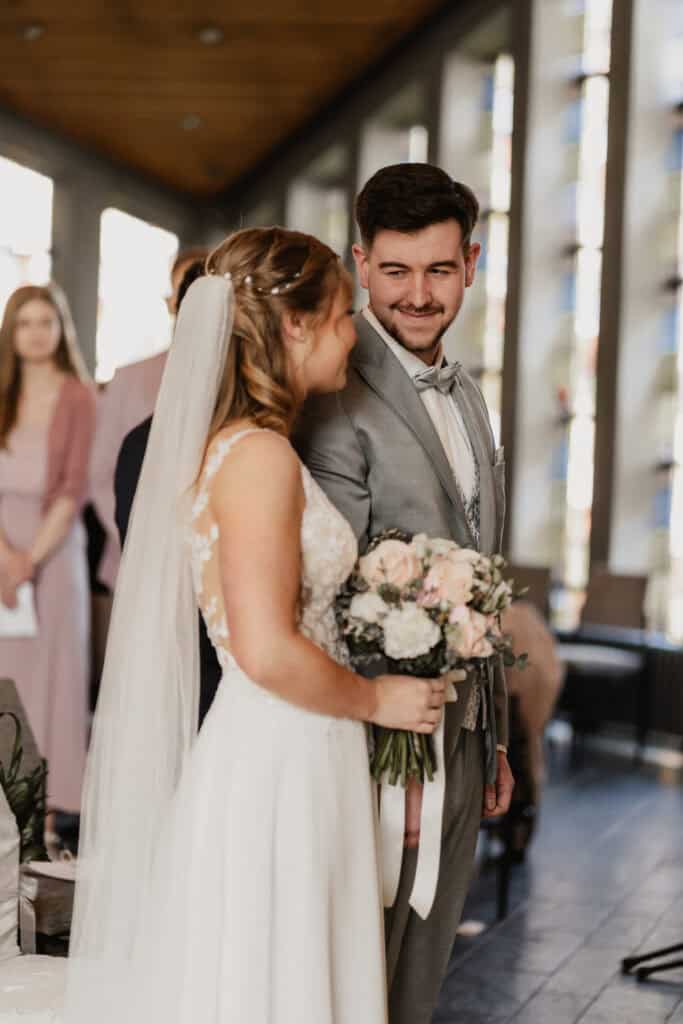 Braut und Bräutigam bei ihrer Hochzeit, glückliches Paar in moderner Kirche.