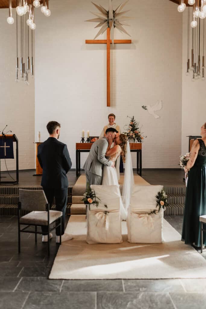 Hochzeit in der Kirche mit Braut, Bräutigam und Gästen.
