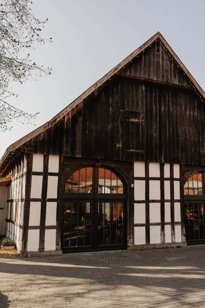 Historisches Fachwerkhaus mit dunklem Holz und weißen Fachwerk-Details.