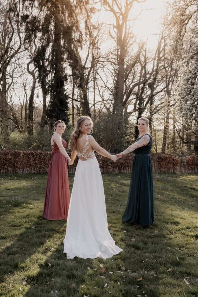 Drei Frauen im Garten bei Sonnenuntergang, Hochzeitskleider, Natur.