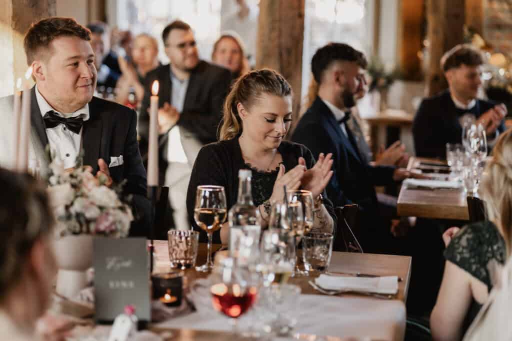 Hochzeitsszene mit lachenden Gästen bei einer Feier.