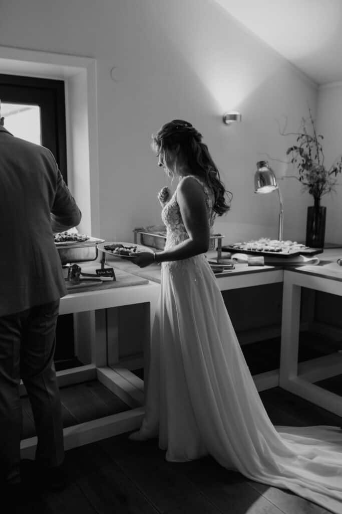 Braut beim Buffet vor ihrer Hochzeit in einem modernen Raum.