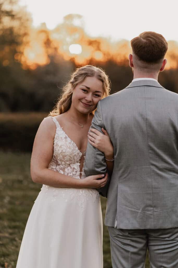 Braut und Bräutigam im Sonnenuntergang bei Hochzeit im Freien.