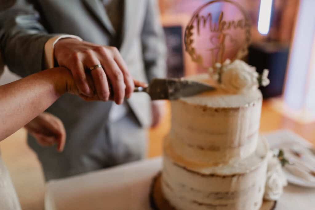 Hochzeitstorte wird bei einer Hochzeit angeschnitten.