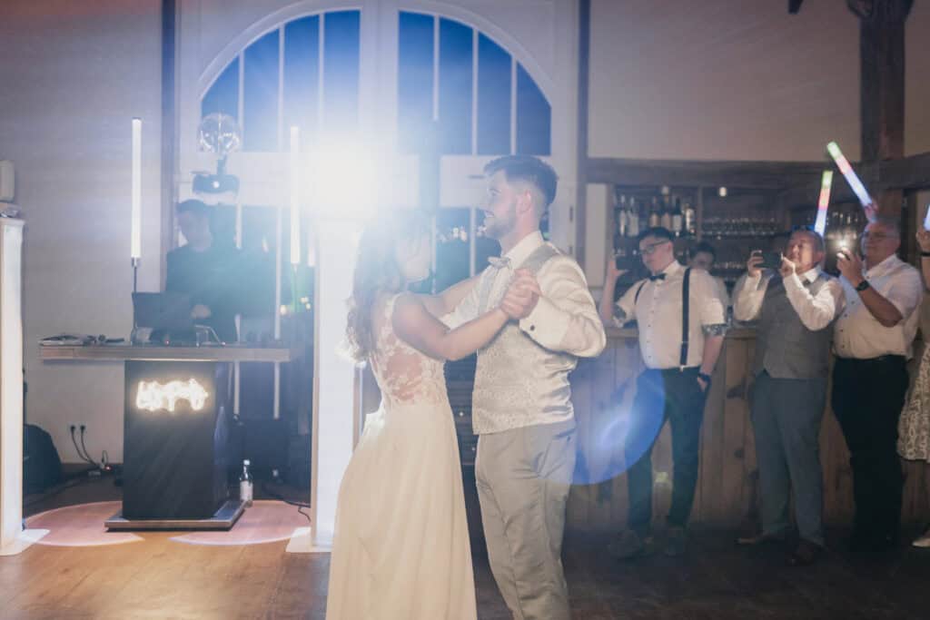 Braut und Bräutigam tanzen bei ihrer Hochzeit mit Tanzmusik im Hintergrund.