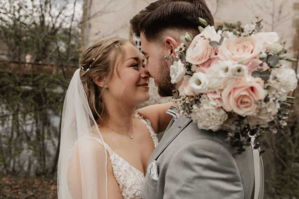Braut und Bräutigam mit Blumenstrauß bei Hochzeit in Natur.