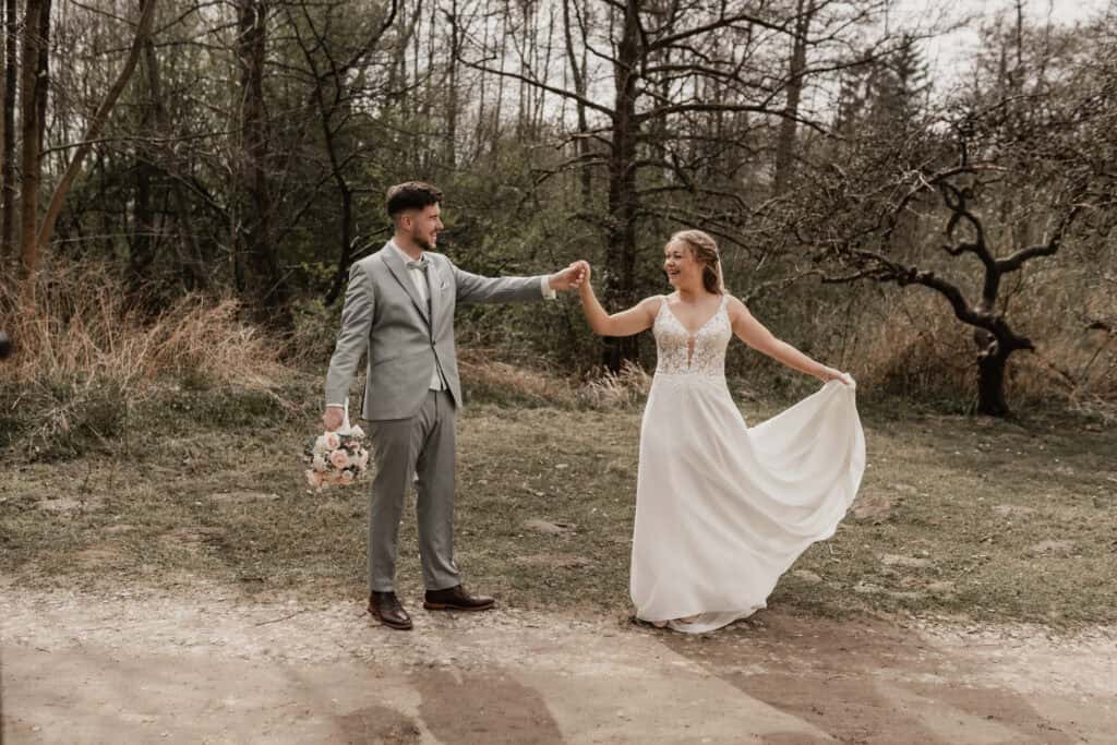Braut und Bräutigam tanzen im Wald bei Hochzeit.