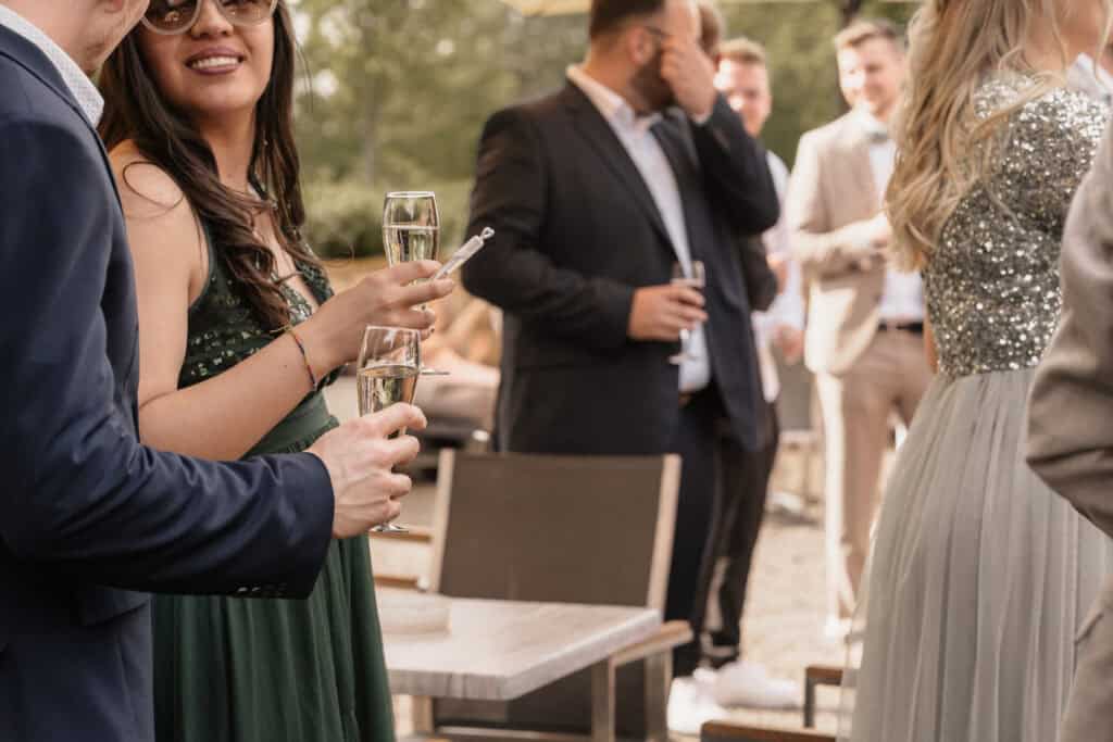 Hochzeitsparty im Freien mit Gästen, die Sekt trinken und feiern.