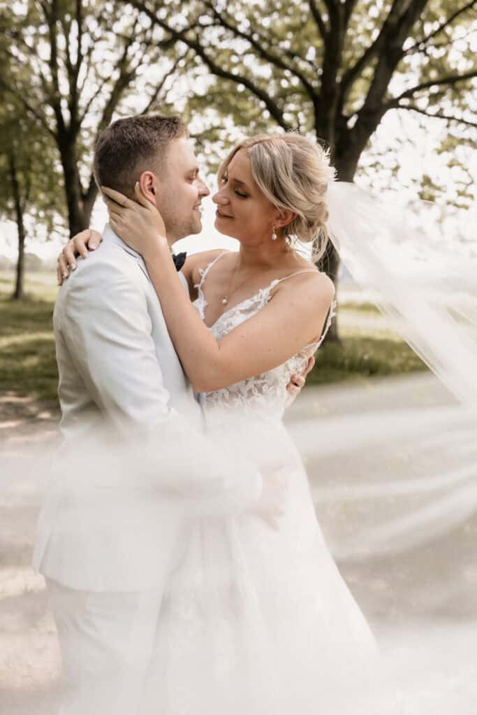Hochzeitspaar im Park, romantisches Brautpaarfoto bei Sonnenuntergang.
