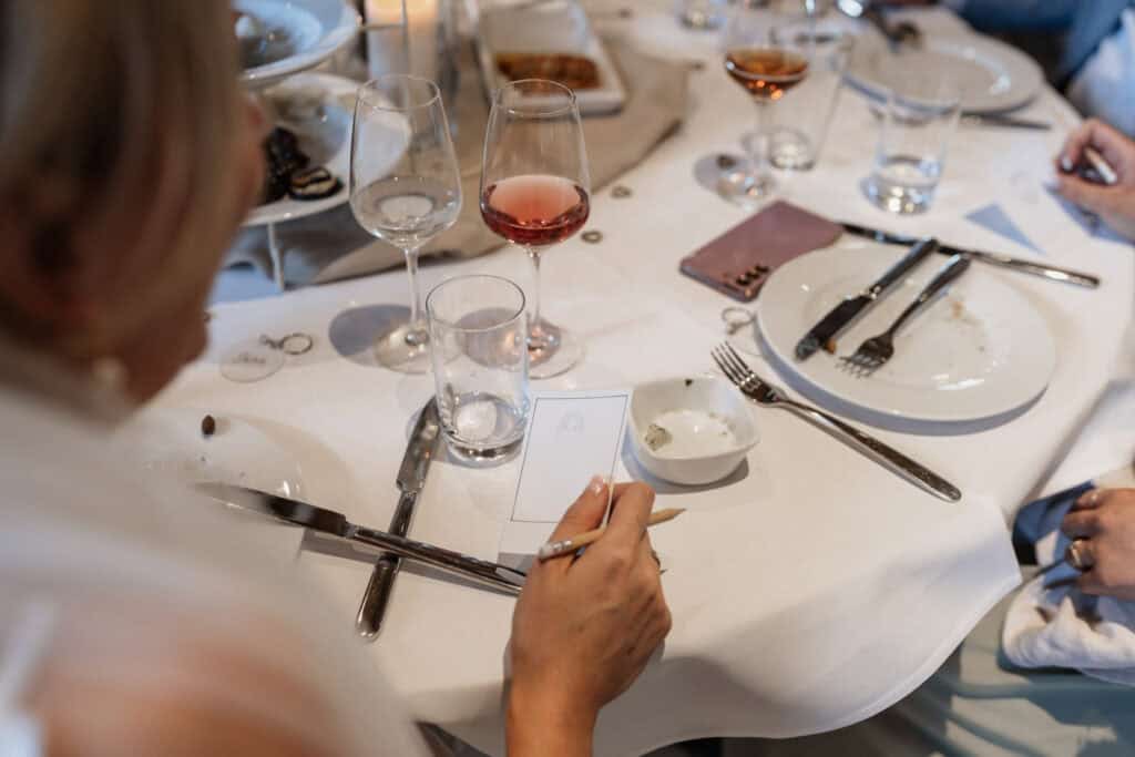 Elegantes gedeckter Tisch bei einer Hochzeit mit Weingläsern und Besteck.