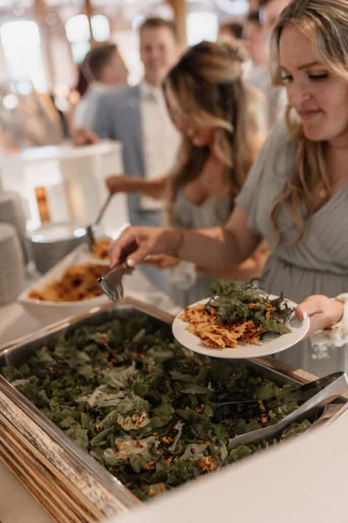 Hochzeitssaal mit Buffet und Gästen beim Essen.