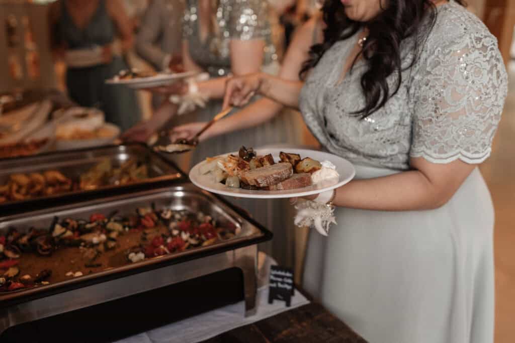 Hochzeitspaar beim Buffet mit leckerem Essen und Dessert.