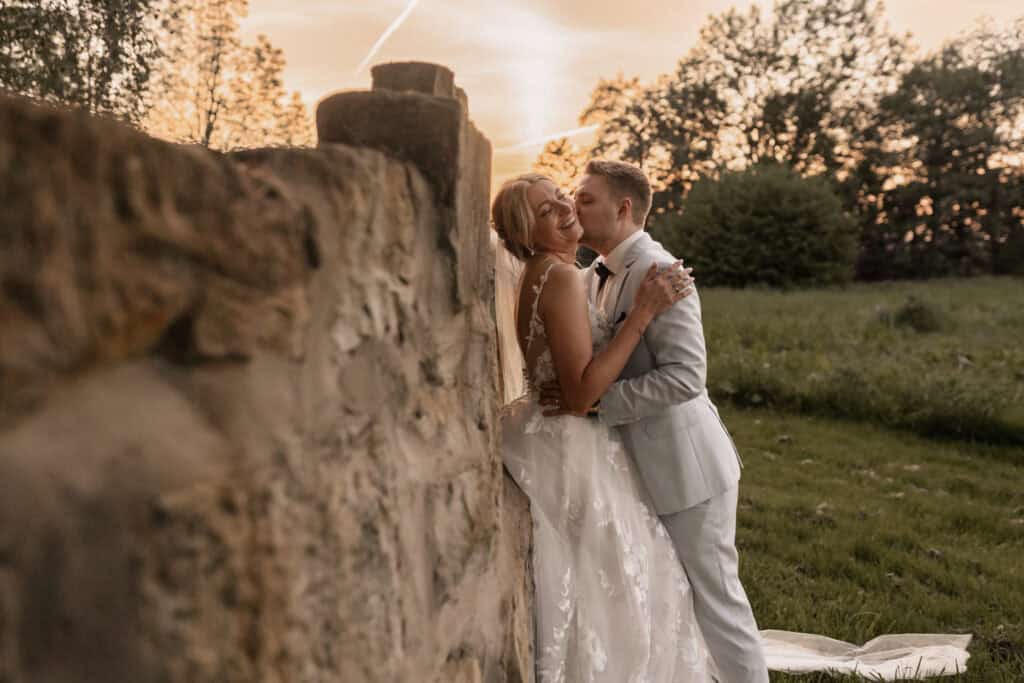 Braut und Bräutigam bei Sonnenuntergang im Grünen.