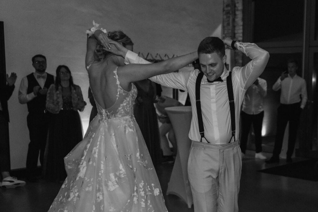 Braut und Bräutigam tanzen auf der Hochzeit, fröhliche Stimmung.