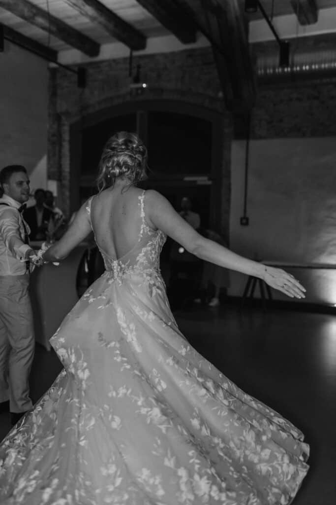 Braut in eleganter Hochzeitskleidung tanzt auf der Tanzfläche.