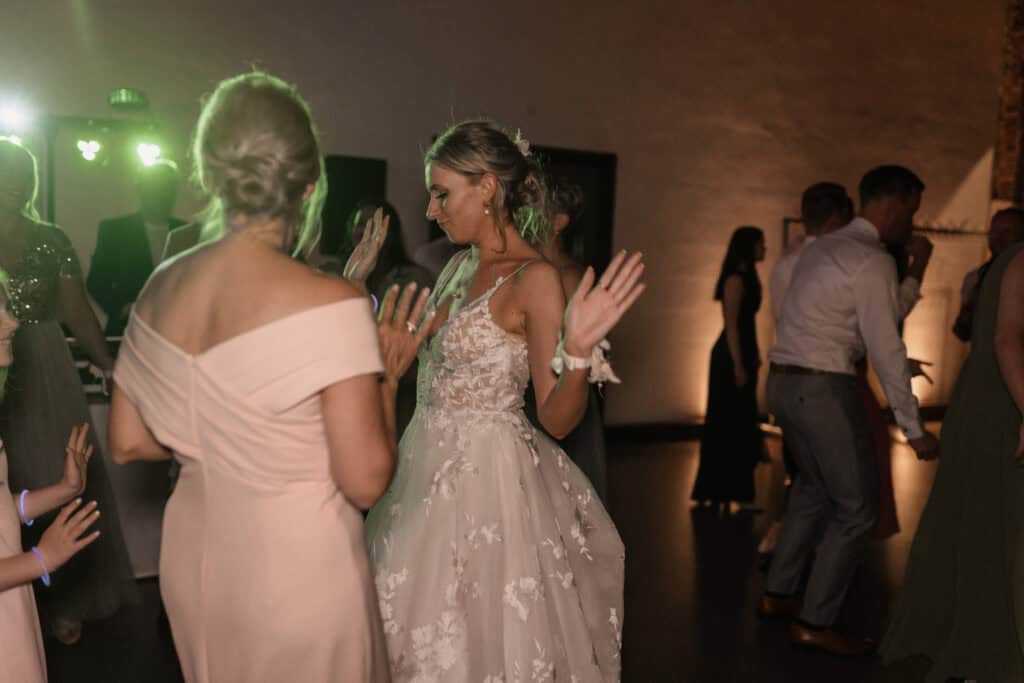 Braut und Gäste tanzen auf einer Hochzeitsparty bei Nacht.