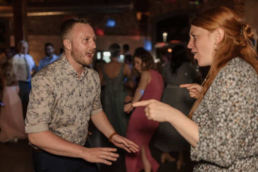 Menschen beim Tanzen auf einer Feier, fröhliche Stimmung, lockere Atmosphäre.