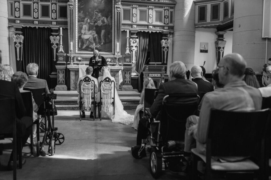 Hochzeit in einer historischen Kirche mit Gästen und Brautpaar.