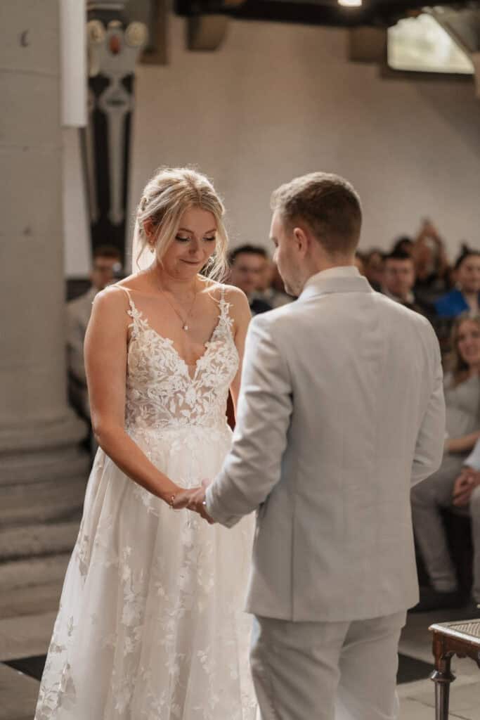Hochzeitspaar bei der Trauung, Braut in weißem Kleid, Bräutigam in Anzug.