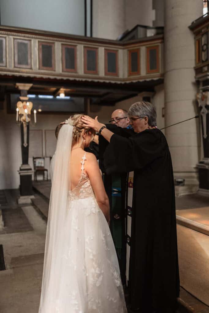 Braut erhält den letzten Segen im Kircheninneren.