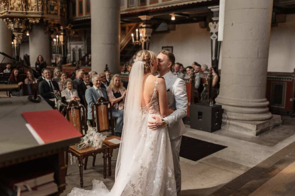 Braut und Bräutigam küssen sich bei ihrer Hochzeit in der Kirche.