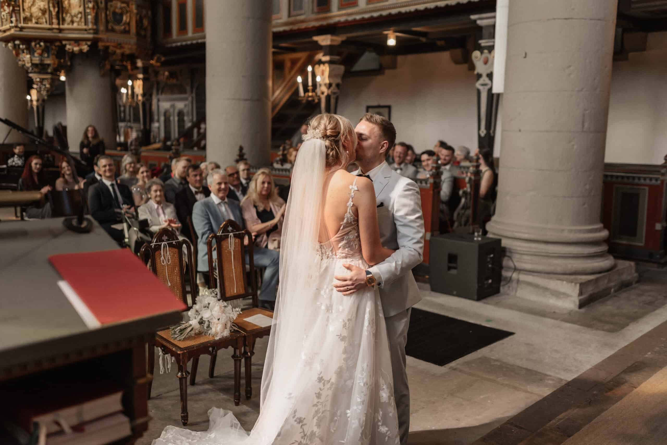 Braut und Bräutigam küssen sich bei ihrer Hochzeit in der Kirche.