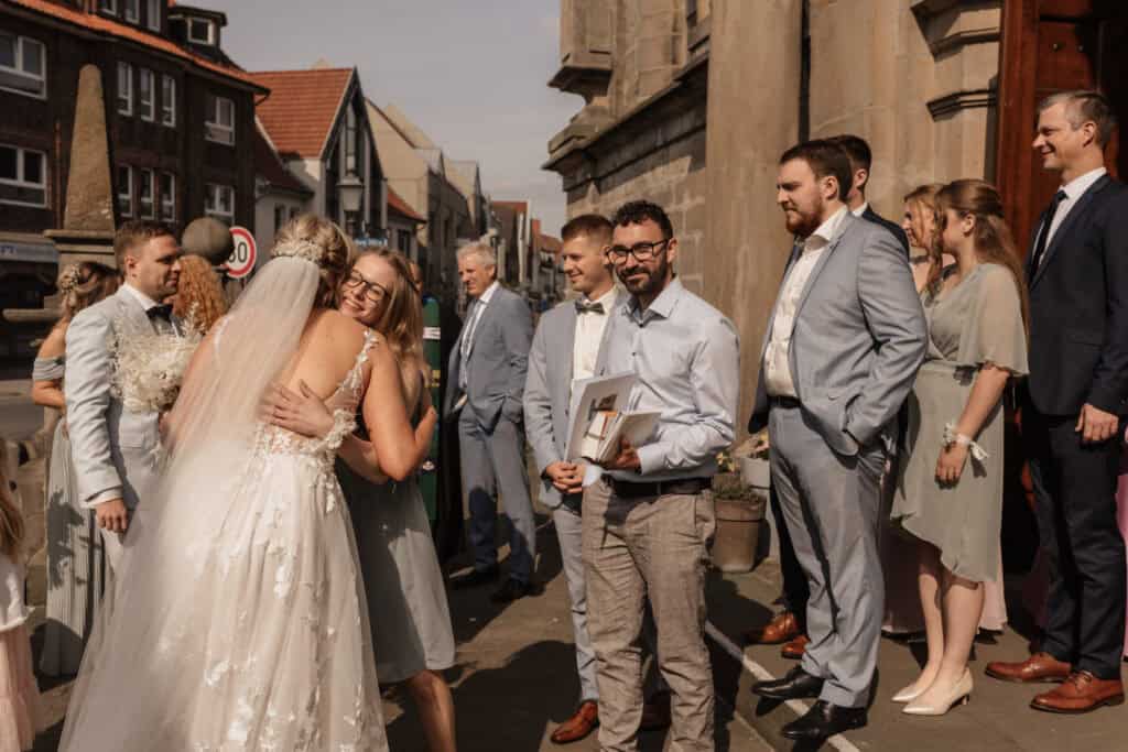 Hochzeitsszene mit Braut, Gästen und Fotograf in der Altstadt.