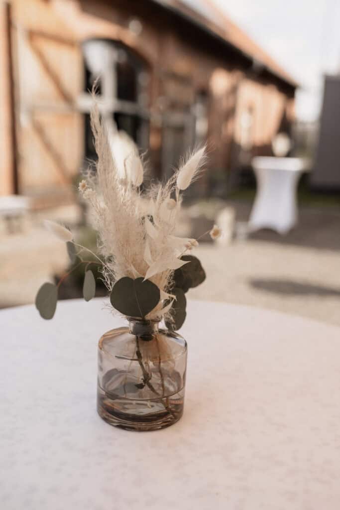 Dekorative Blumen in einer Glasvase bei einer Hochzeit.