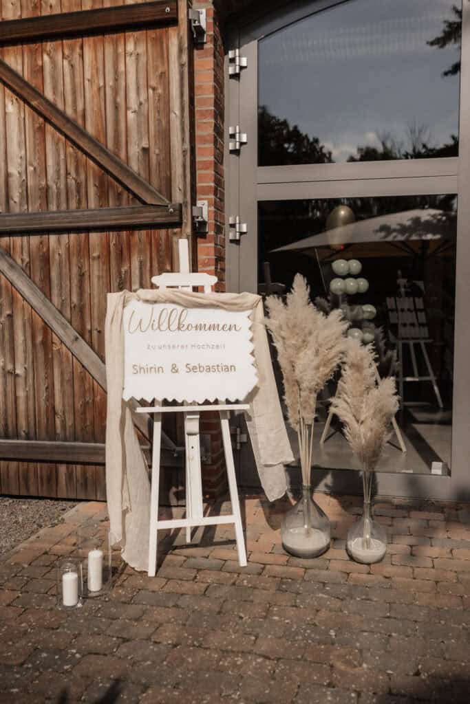 Willkommensschild für Hochzeit von Shirin & Sebastian vor einem Gebäude.