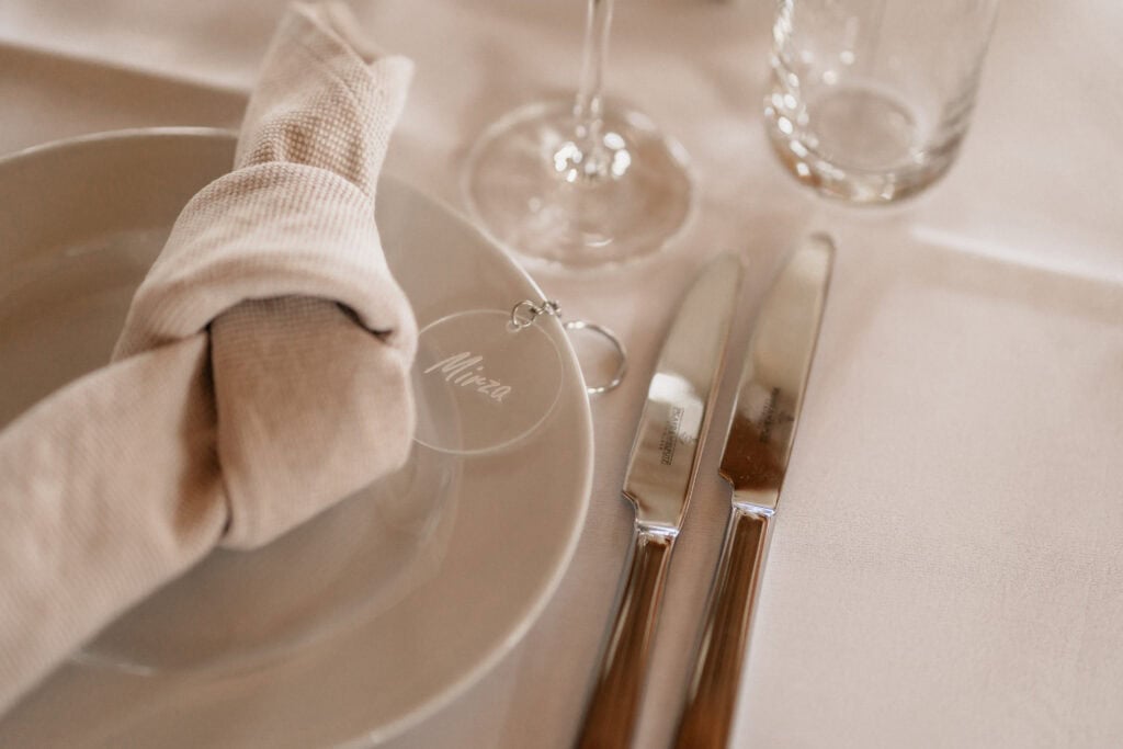 Elegantes gedeckter Tisch mit Glas, Besteck und Serviette für Hochzeitsfeier.