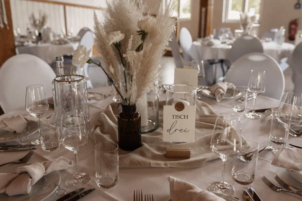 Eleganter Tisch mit Blumen und Dekoration bei einer Hochzeit.
