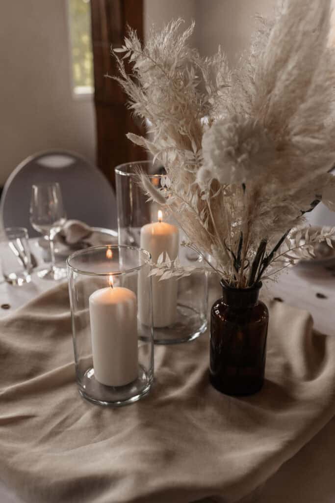 Elegante Tischdekoration mit Kerzen und Trockenblumen für Hochzeit oder Event.